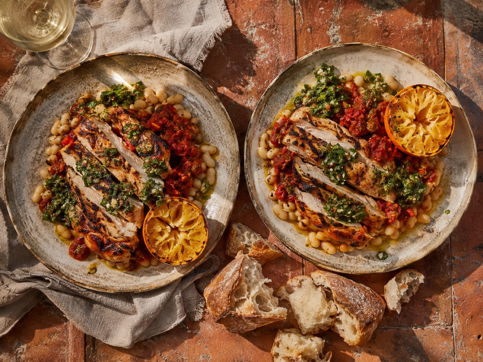 Bord met Spaanse kip, witte bonen, salsa roja en een gegrilde sinaasappel